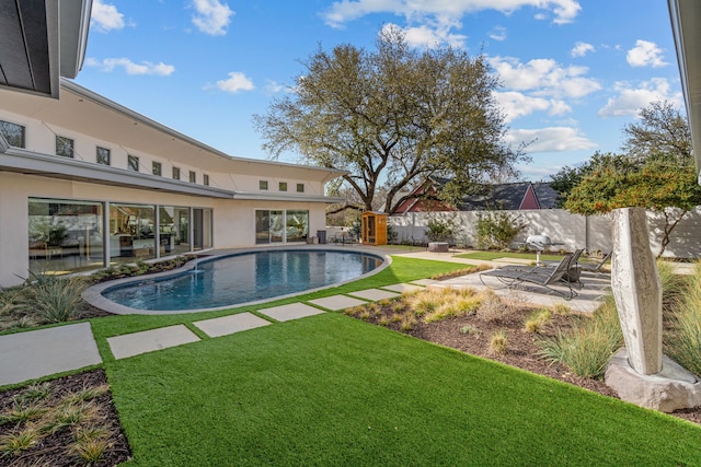 view of swimming pool featuring a yard, a patio area, a fenced in pool, and a fenced backyard