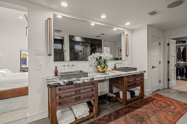 ensuite bathroom featuring a sink, double vanity, recessed lighting, and connected bathroom