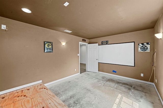 cinema with unfinished concrete floors, visible vents, and baseboards