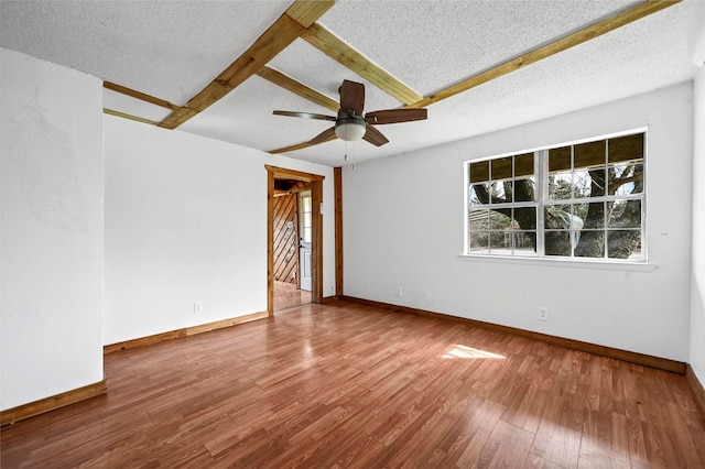 unfurnished room featuring ceiling fan, baseboards, a textured ceiling, and wood finished floors