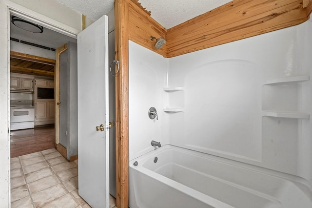 full bathroom with shower / bath combination, a textured ceiling, and tile patterned flooring