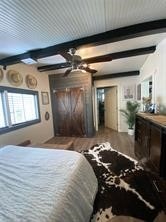 bedroom featuring beam ceiling and wood finished floors