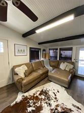 living area with lofted ceiling with beams and wood finished floors