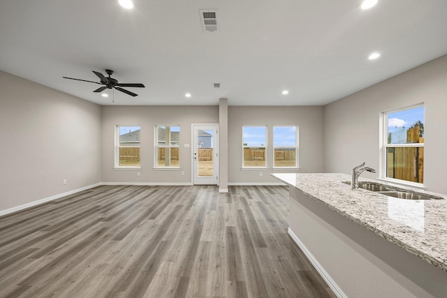 unfurnished living room with visible vents, recessed lighting, wood finished floors, and a sink