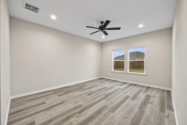 unfurnished room featuring visible vents, baseboards, and wood finished floors