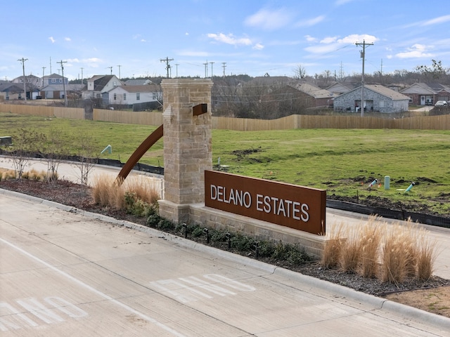 community sign with a residential view, a lawn, and fence