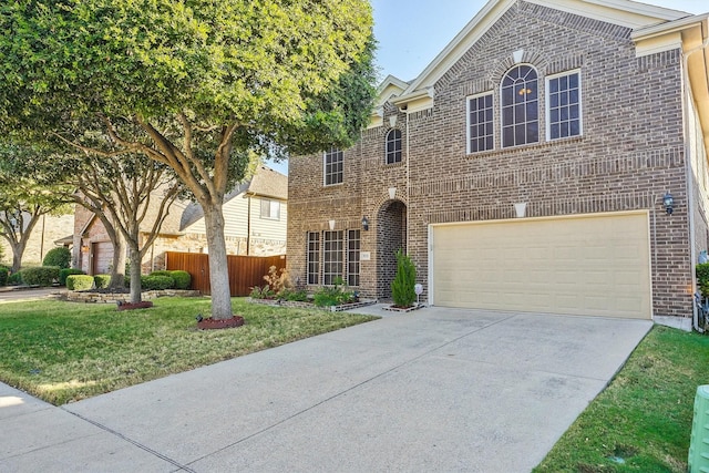 traditional home with brick siding, concrete driveway, a front lawn, and fence