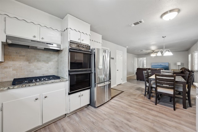 kitchen with visible vents, under cabinet range hood, backsplash, appliances with stainless steel finishes, and light wood finished floors