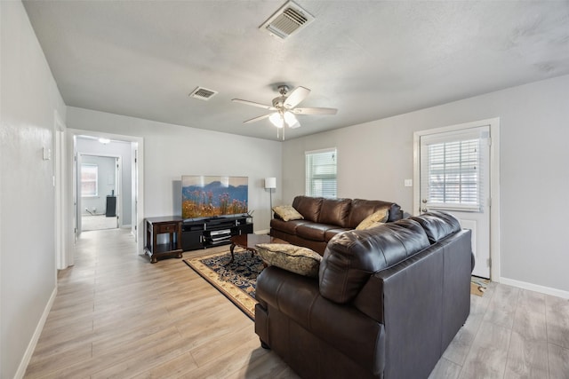 living area with ceiling fan, visible vents, baseboards, and light wood-style flooring