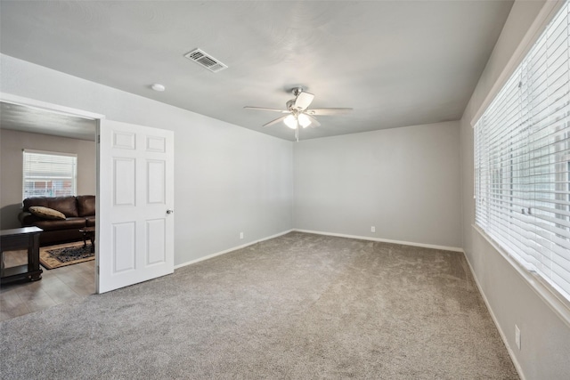 unfurnished room featuring a ceiling fan, baseboards, visible vents, and carpet floors