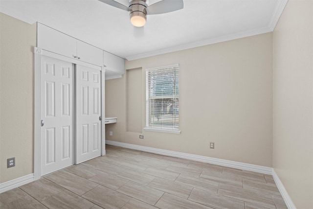 unfurnished bedroom with crown molding, a ceiling fan, baseboards, and a closet