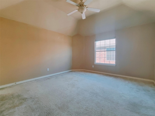 empty room featuring baseboards, lofted ceiling, carpet floors, and a ceiling fan