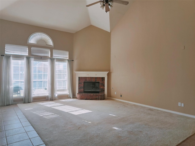 unfurnished living room with carpet, high vaulted ceiling, ceiling fan, tile patterned flooring, and a brick fireplace