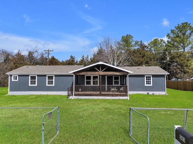 back of property with a yard and fence