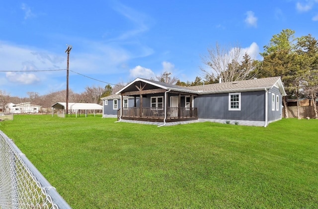 view of front of home featuring a deck, a front yard, and fence