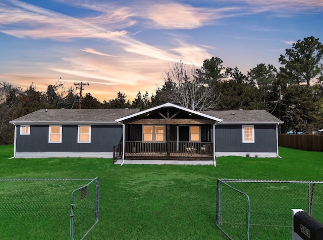 view of front of home featuring a yard, a shingled roof, and fence