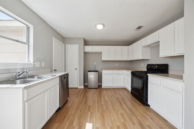 kitchen featuring black gas range oven, visible vents, a sink, dishwasher, and light wood-type flooring