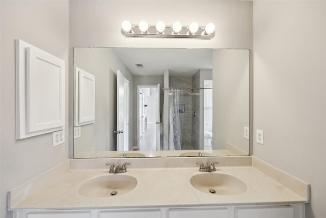 full bath featuring a sink, visible vents, a stall shower, and double vanity