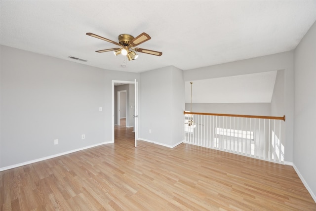 empty room with visible vents, baseboards, a ceiling fan, and light wood finished floors