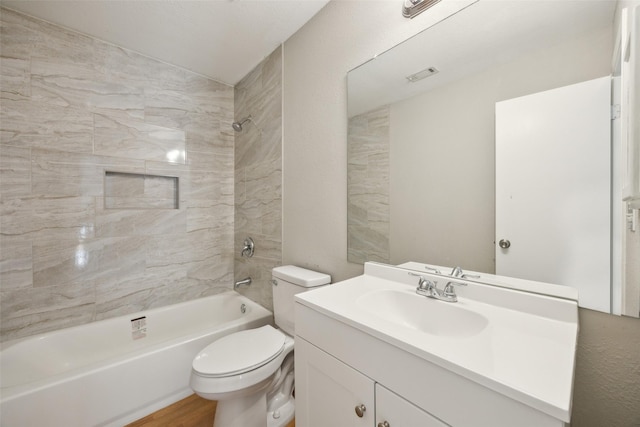 full bath featuring vanity, wood finished floors, visible vents, shower / bathing tub combination, and toilet