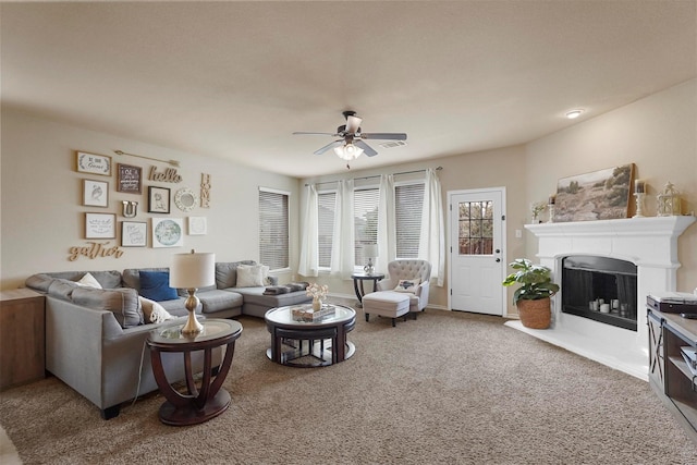 living room with visible vents, a ceiling fan, carpet flooring, a fireplace, and baseboards