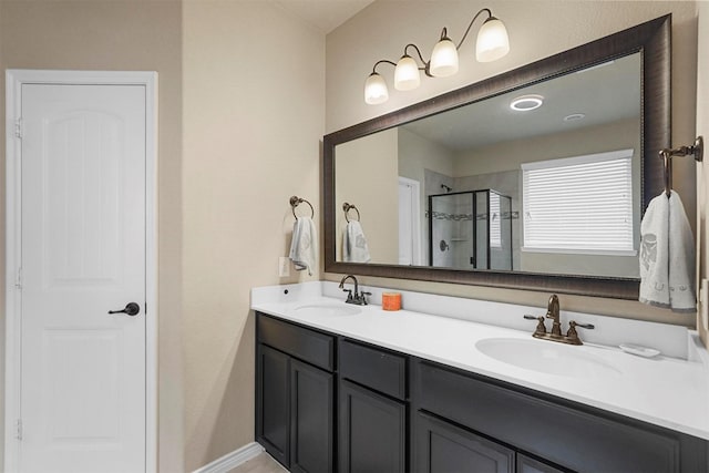 full bathroom featuring double vanity, a stall shower, and a sink