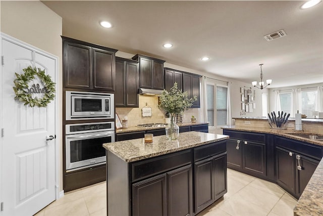 kitchen with light tile patterned floors, visible vents, a sink, stainless steel appliances, and a chandelier