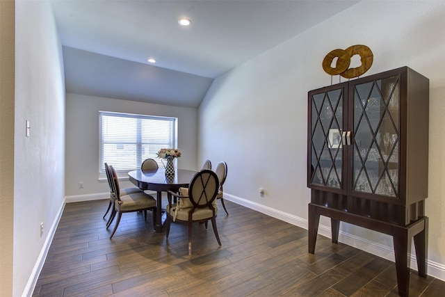 dining space with dark wood-type flooring, baseboards, and vaulted ceiling