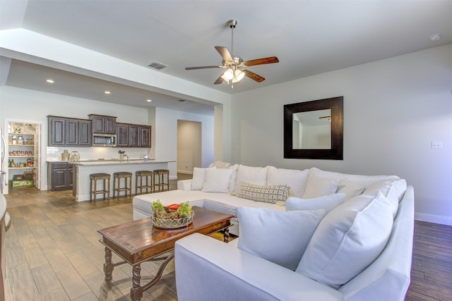 living room featuring visible vents, baseboards, ceiling fan, dark wood finished floors, and recessed lighting