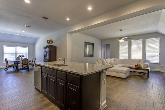 kitchen featuring visible vents, wood tiled floor, a sink, vaulted ceiling, and stainless steel dishwasher