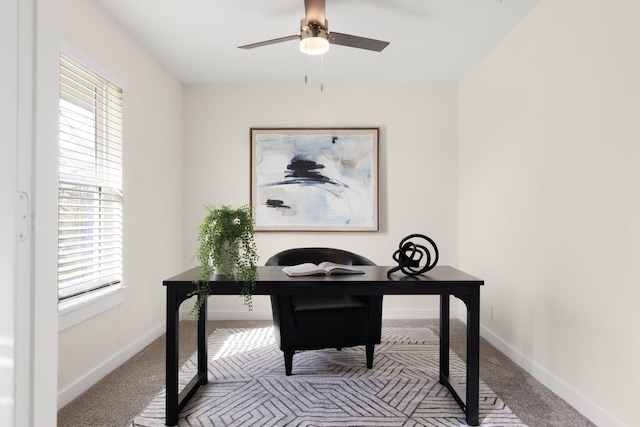 carpeted office with baseboards and ceiling fan