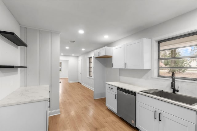 kitchen featuring dishwasher, decorative backsplash, light wood-style floors, white cabinetry, and a sink