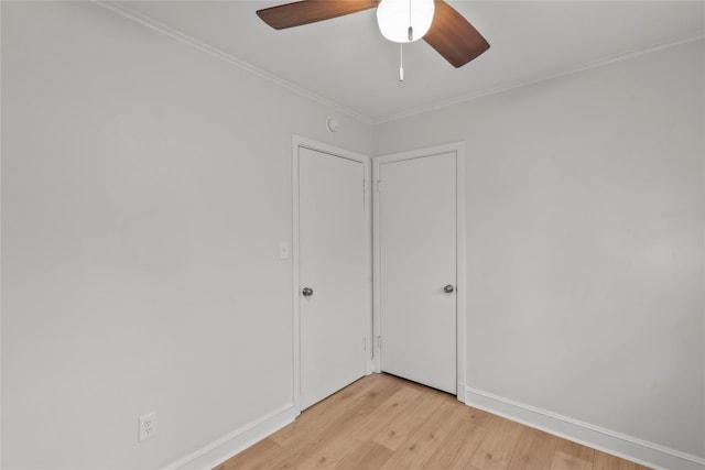 unfurnished room featuring baseboards, a ceiling fan, crown molding, and light wood finished floors