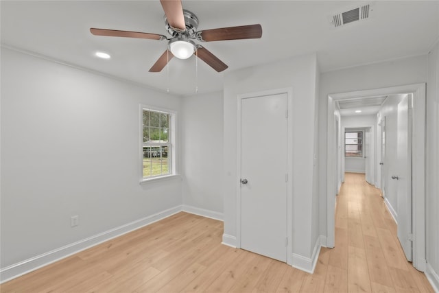 unfurnished bedroom with a ceiling fan, light wood-style floors, visible vents, and baseboards