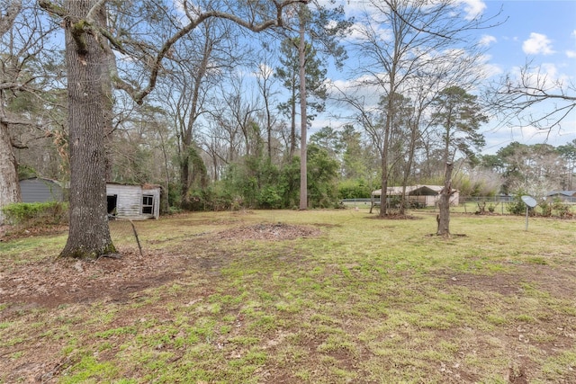 view of yard featuring an outdoor structure and fence