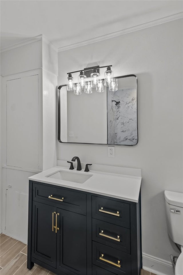 bathroom featuring vanity, baseboards, wood tiled floor, crown molding, and toilet