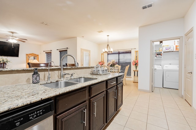 kitchen featuring visible vents, light tile patterned flooring, a sink, stainless steel dishwasher, and washing machine and dryer