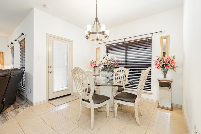 dining area featuring a wealth of natural light, a barn door, light tile patterned flooring, and a chandelier