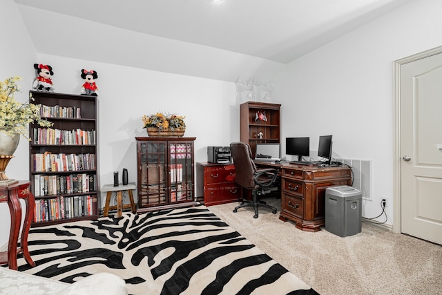 carpeted office with visible vents and vaulted ceiling