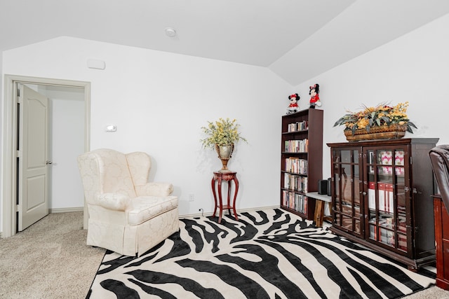 living area featuring baseboards, lofted ceiling, and carpet floors