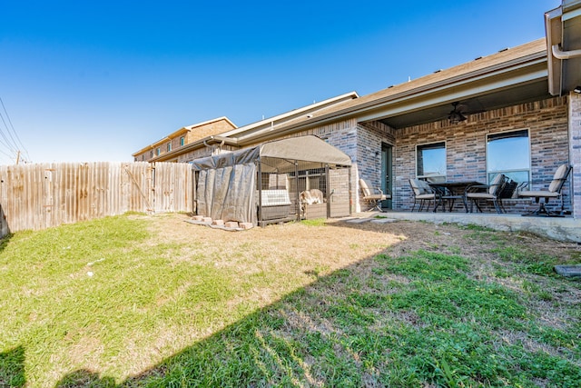 view of yard with a patio area, a ceiling fan, and a fenced backyard