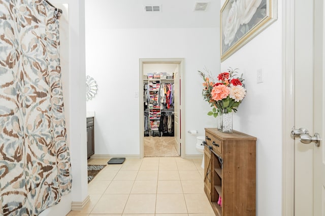 interior space featuring light tile patterned flooring, baseboards, and visible vents