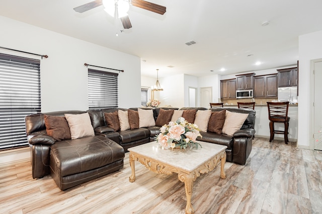 living area with recessed lighting, visible vents, light wood-style flooring, and ceiling fan with notable chandelier