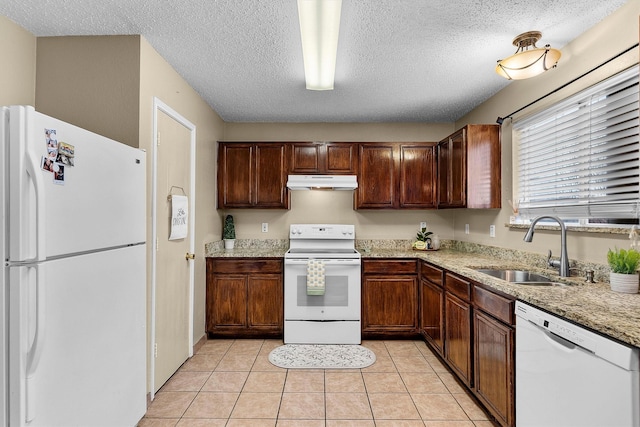 kitchen featuring under cabinet range hood, light tile patterned floors, white appliances, a textured ceiling, and a sink