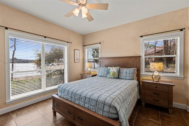 tiled bedroom with baseboards and a ceiling fan