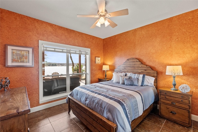 tiled bedroom with access to exterior, ceiling fan, baseboards, and a water view