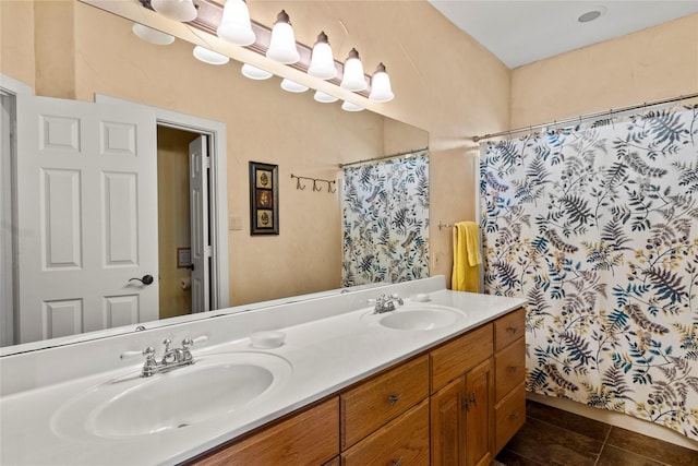 full bath with a sink, a shower with shower curtain, double vanity, and tile patterned floors