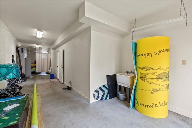 garage featuring baseboards and a sink