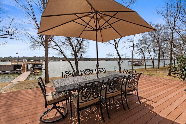 deck featuring outdoor dining space, a dock, and a water view