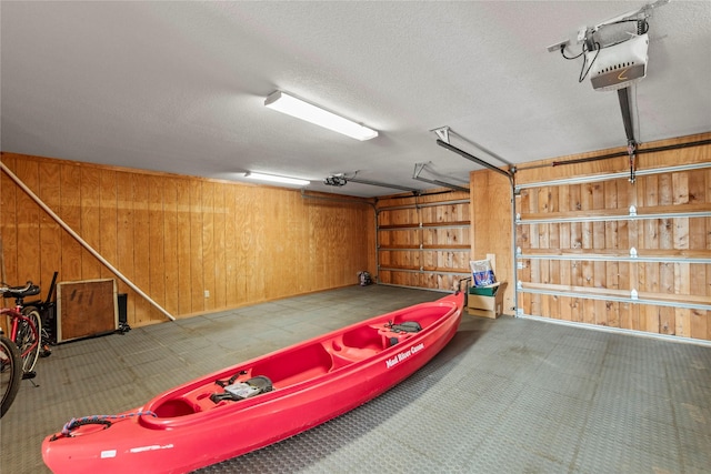 garage featuring a garage door opener and wood walls